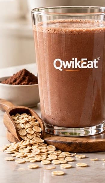 A glass of prepared chocolate QwikEat beside oats and cocoa